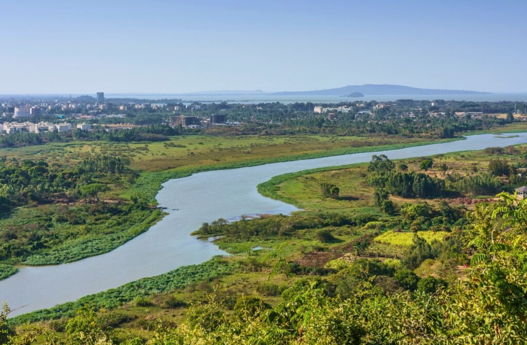 View of the Blue Nile River flowing through Bahir Dar, Ethiopia with greenery and cityscape in the background