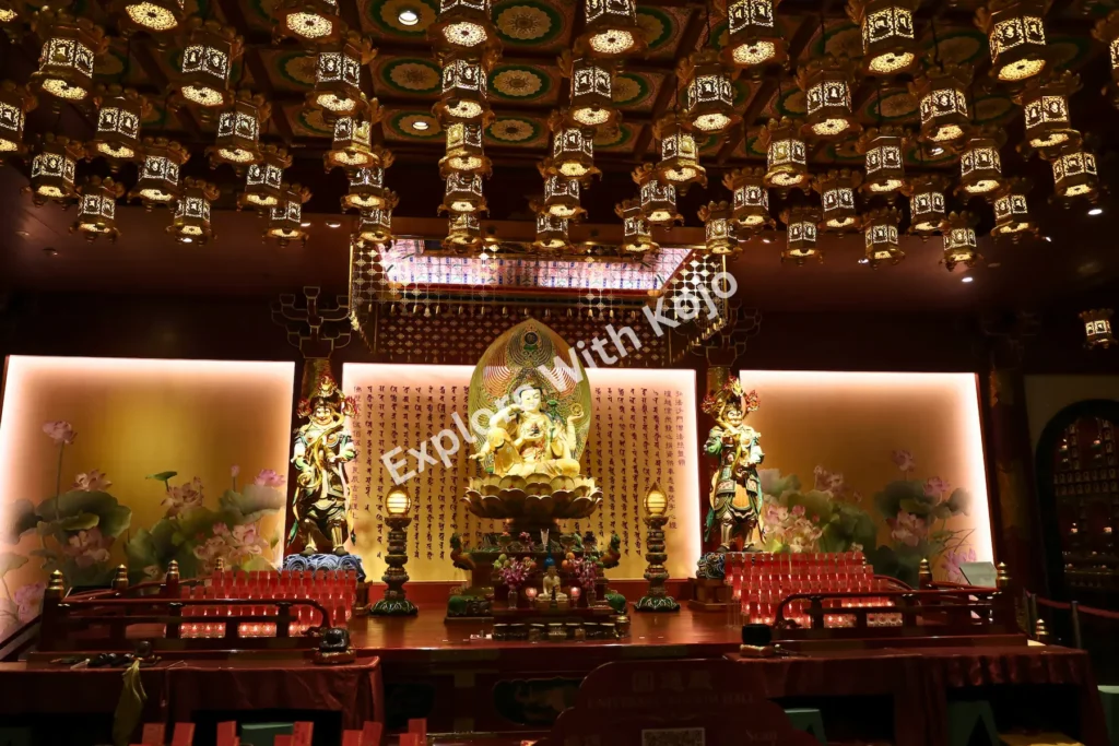 emple hall with golden Buddha statue and ceiling filled with lanterns.