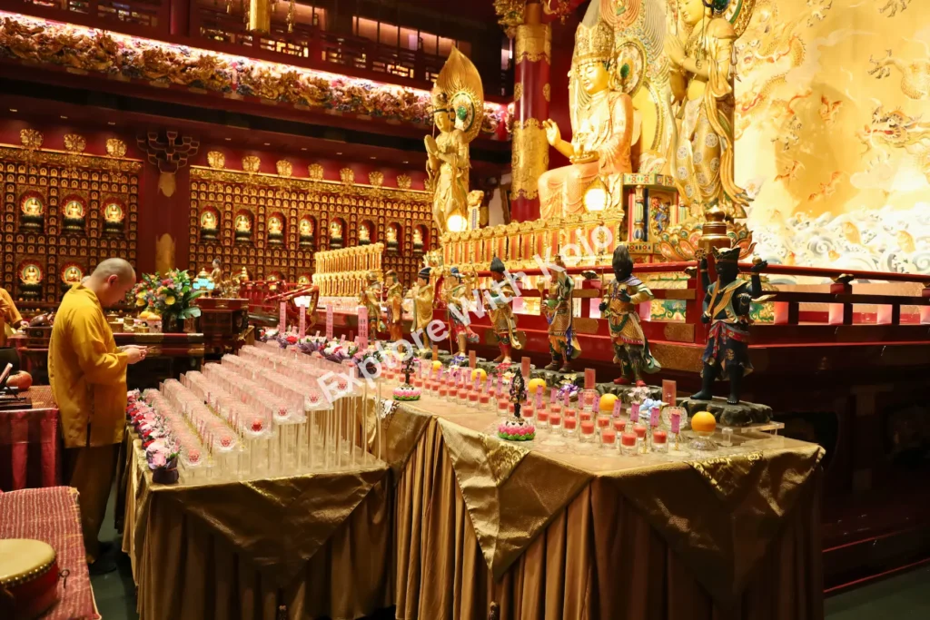 Devotee placing offerings at a golden altar table inside the temple.