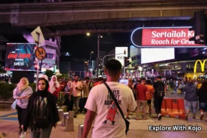 Pedestrian crossing at Bukit Bintang under neon billboards at night