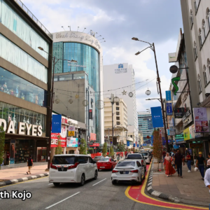 Street in Bukit Bintang Kuala Lumpur with shops, restaurants, and traffic