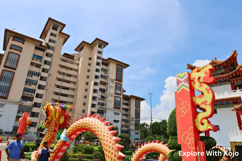 Dragon statues at Thean Hou Temple in Kuala Lumpur with high-rise buildings in the background.