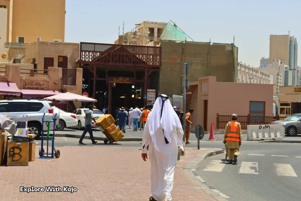 A man in traditional Emirati dress walks through Dubai’s Old Souk, reflecting the cultural and religious life of the city.