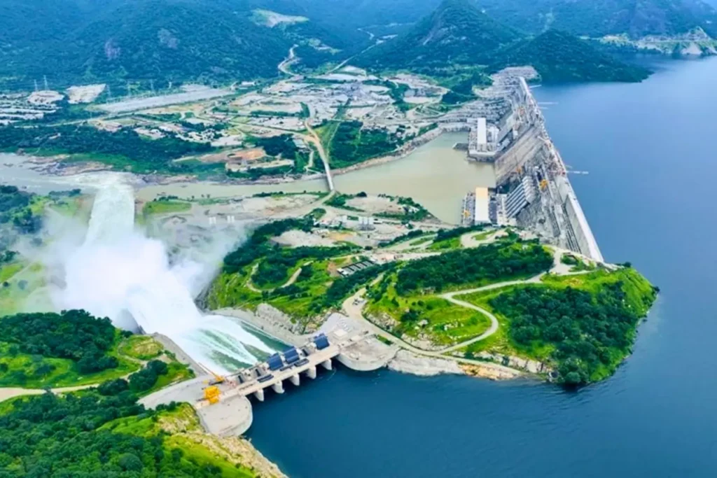 Wide aerial view of the Grand Ethiopian Renaissance Dam with water release and surrounding areas