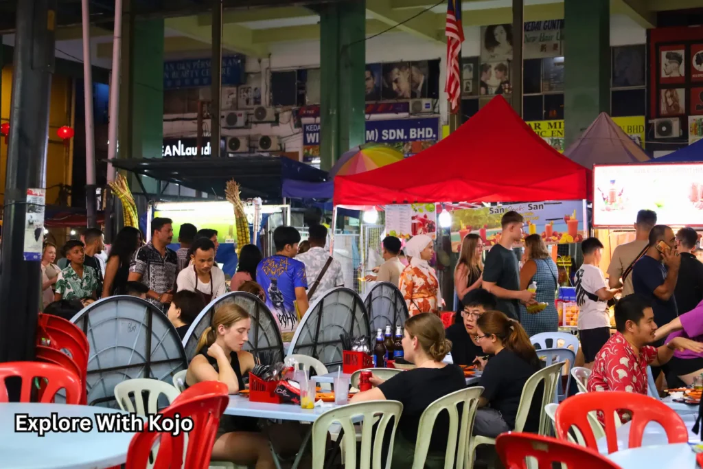 Jalan Alor’s crowded food court with red tents and food stalls Jalan Alor Busy Food Court at Night