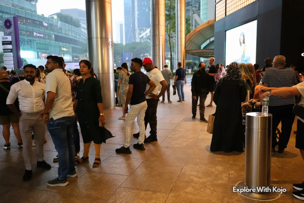 Evening crowd gathering inside a shopping or city center in Kuala Lumpur.