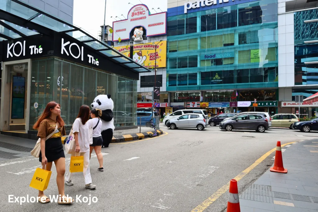 Street scene in Kuala Lumpur with people walking and shops in the background, representing Malaysia’s decision to ban Sugarbook dating app