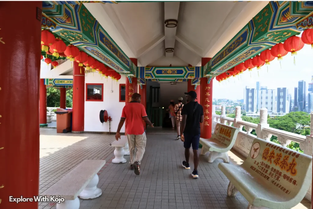 Crowds inside Thean Hou Temple with golden statues and red columns in Kuala Lumpur