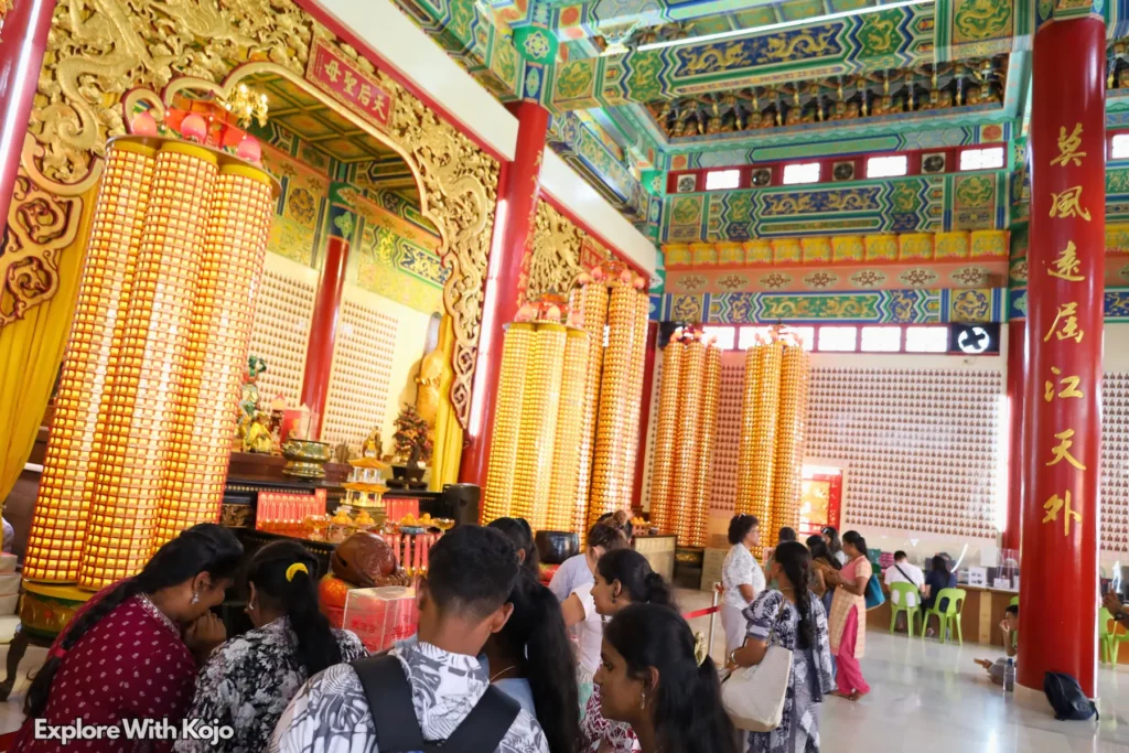 Visitors walking through the colorful corridor of Thean Hou Temple in Kuala Lumpur