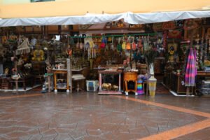 Colorful souvenir shop in Little India, Singapore, selling traditional crafts, statues, jewelry, and textiles.