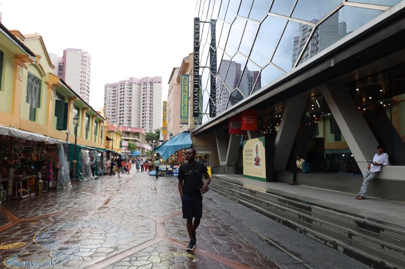 Street view of Little India in Singapore with colorful shophouses, Indian Heritage Centre, and visitors exploring the area.