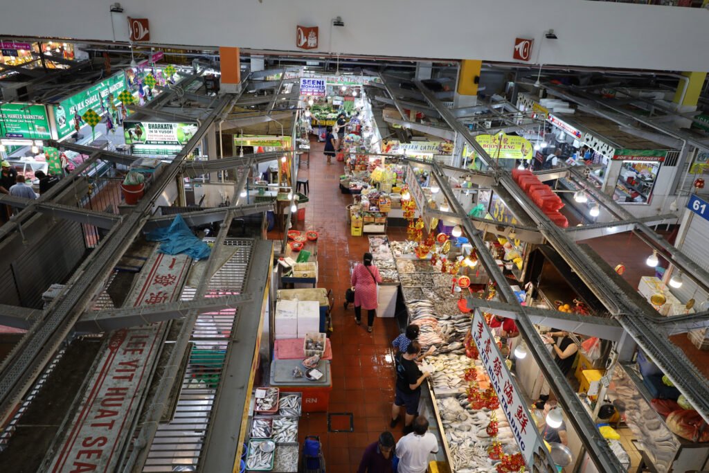 Busy wet market in Little India, Singapore, with fresh fish, seafood, and produce stalls.