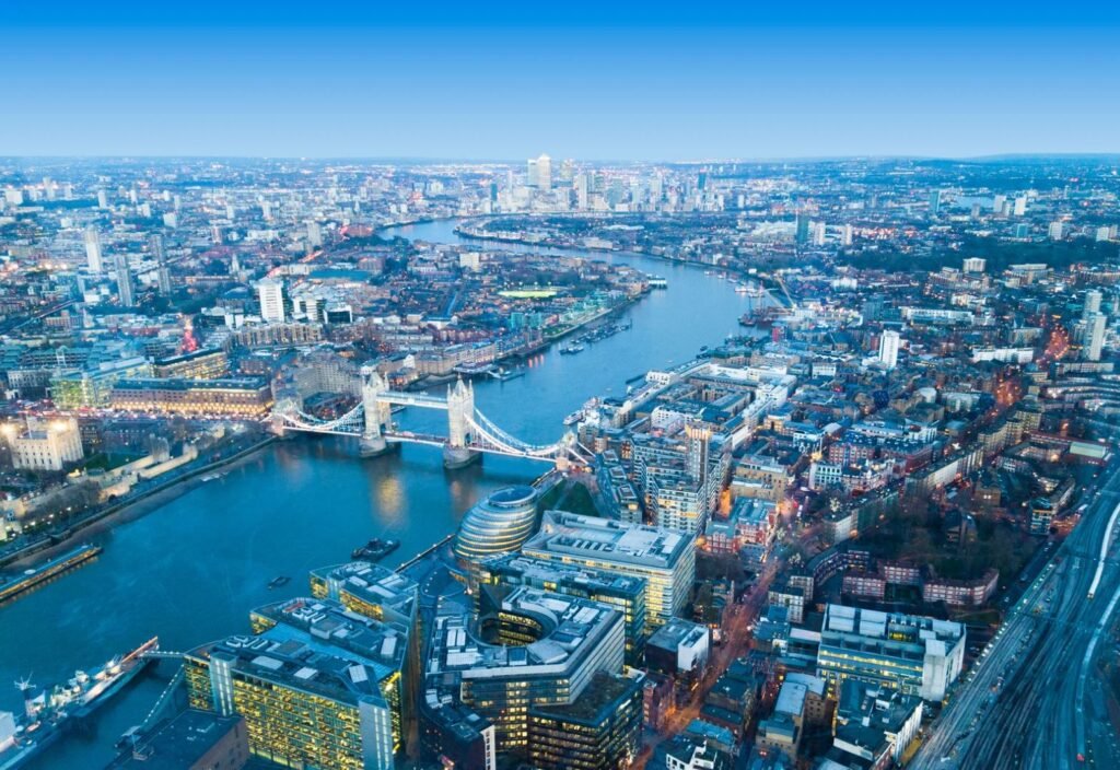 Aerial view of London city with Tower Bridge and the River Thames, showcasing the modern skyline at dusk.