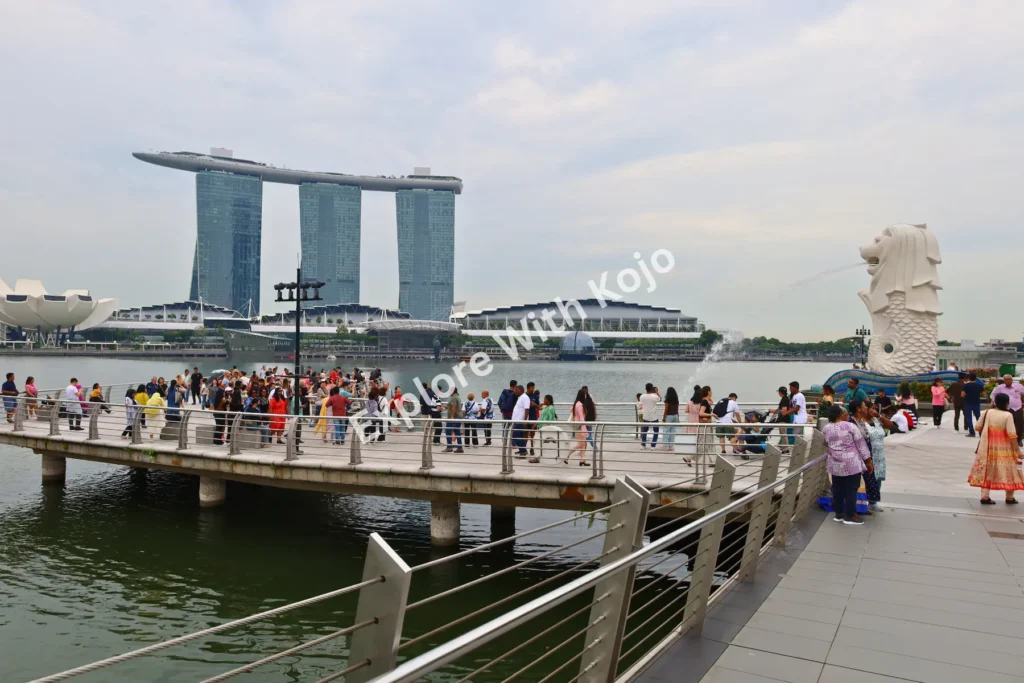 Tourists at Singapore’s Merlion Park with Marina Bay Sands in the background