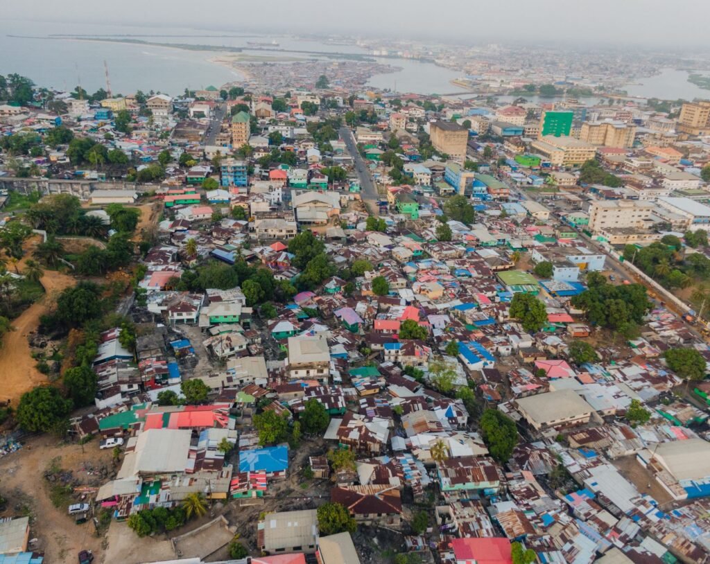 Aerial view of Monrovia, the capital city of Liberia, with colorful rooftops and the Atlantic coastline in the background.