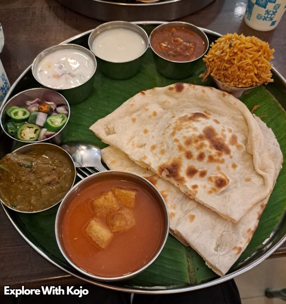 Traditional Indian thali meal in Penang with flatbread, curries and side dishes served on a banana leaf. 