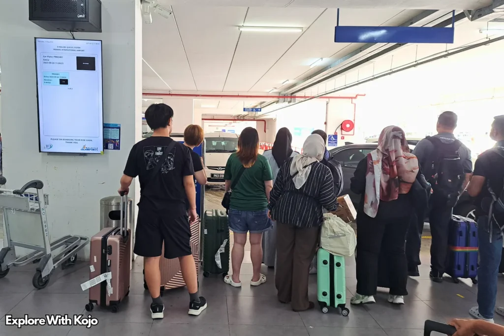 Travelers waiting in line for taxis at Penang International Airport arrival area