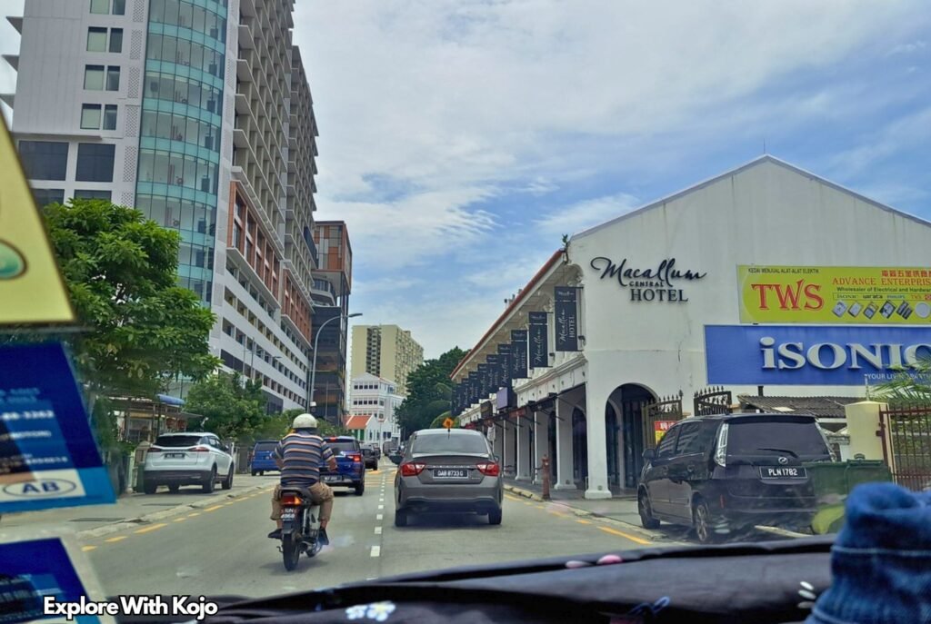 Street view of Penang with Macallum Central Hotel and passing traffic