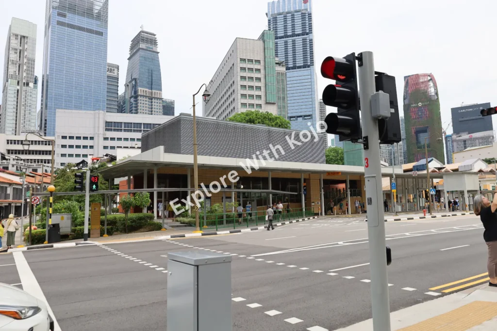 A city street crossing with tall modern skyscrapers in the background in Singapore.