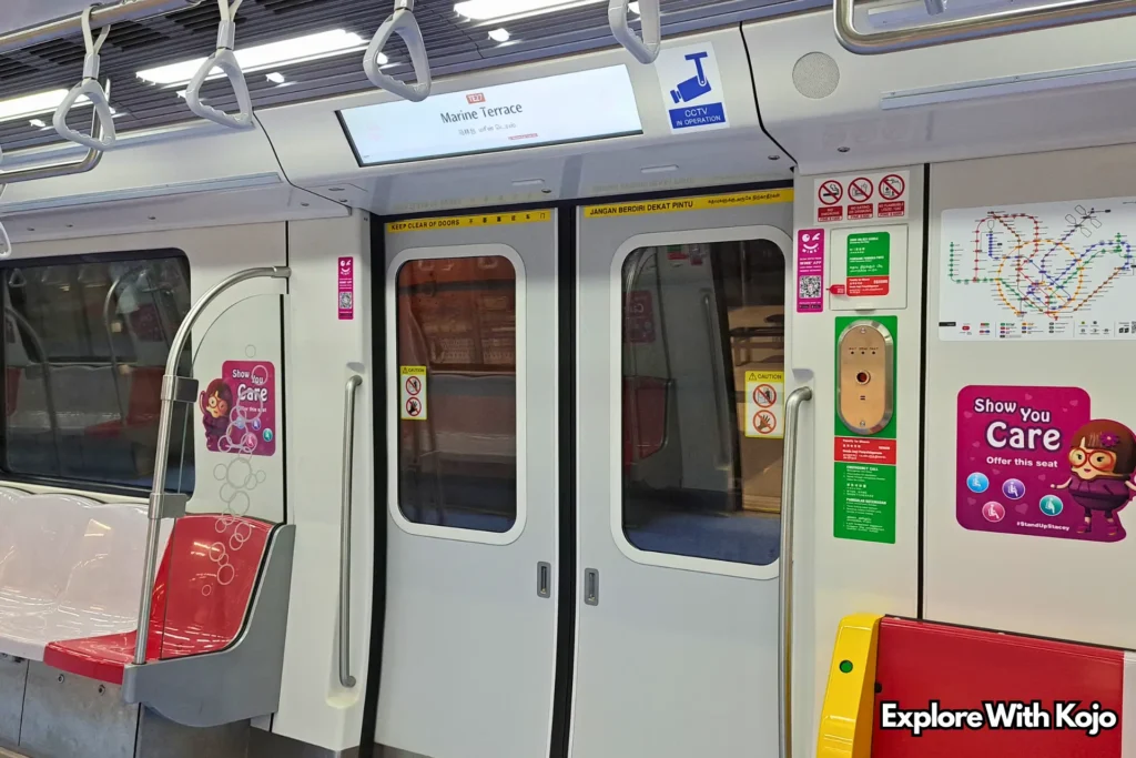 Interior of a Singapore MRT train showing the doors, seats, and Marine Terrace station sign