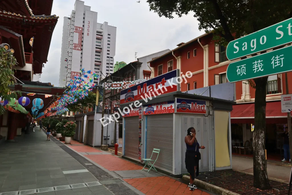 Sago Street in Chinatown Singapore with colorful decorations and the Buddha Tooth Relic Temple in view.