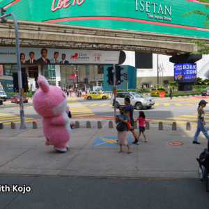 People walking under a large billboard in Bukit Bintang Kuala Lumpur