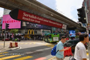Street view of Bukit Bintang with overhead bridge and shops