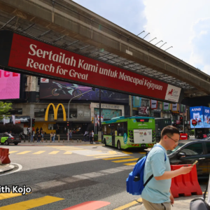 Street view of Bukit Bintang with overhead bridge and shops