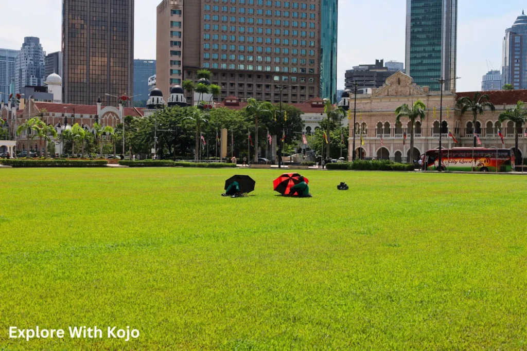 Green lawn with the Sultan Abdul Samad Building and city skyscrapers in the background