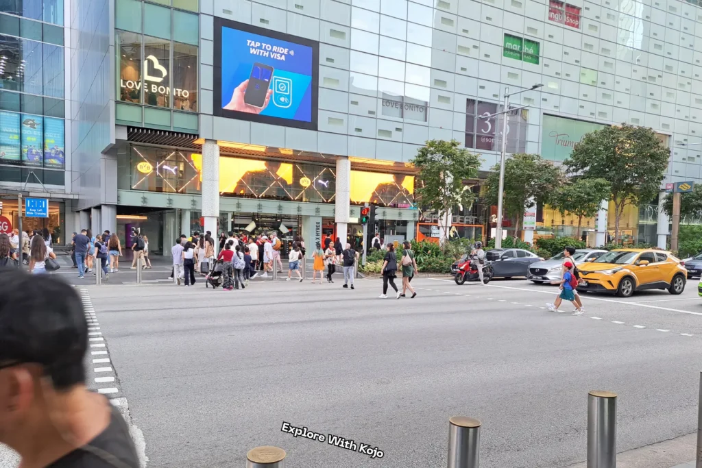 Shoppers crossing the street in front of 313@Somerset mall on Orchard Road Singapore