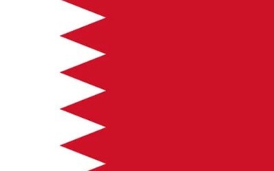 Flag of Bahrain with a white serrated band and red field.
