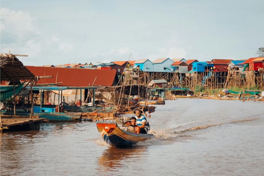 Boats moving through a floating village in Cambodia.