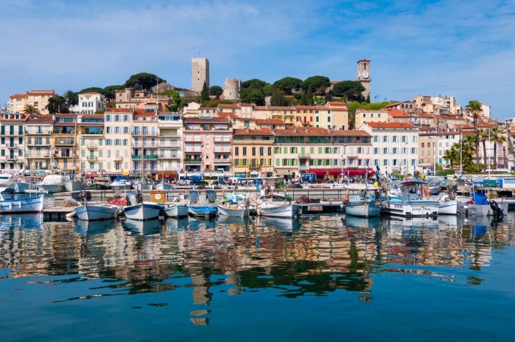 Waterfront of Cannes with luxury yachts and colorful old town buildings