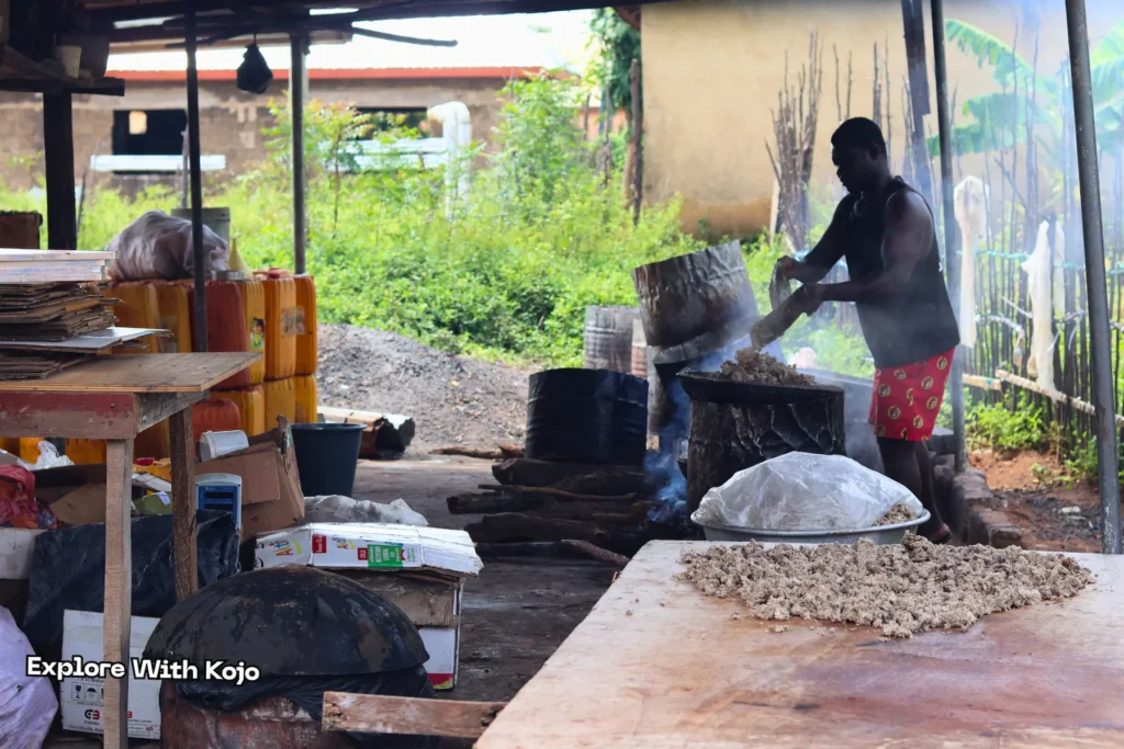 Man scooping freshly made African black soap into a pan in Tamale, Ghana