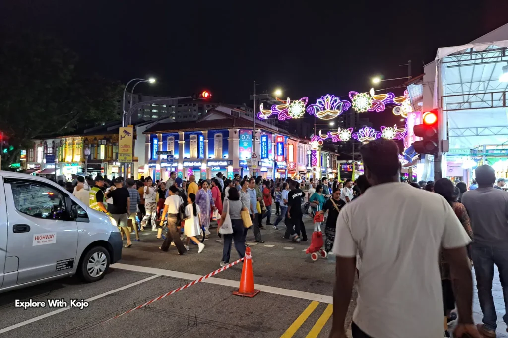 Large crowd crossing the street under Deepavali lights at Little India Singapore.