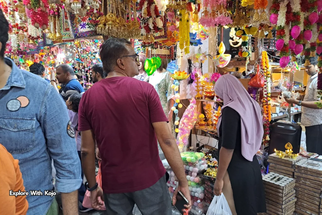 Stalls selling clay lamps, garlands, and religious items at a Deepavali market in Singapore.