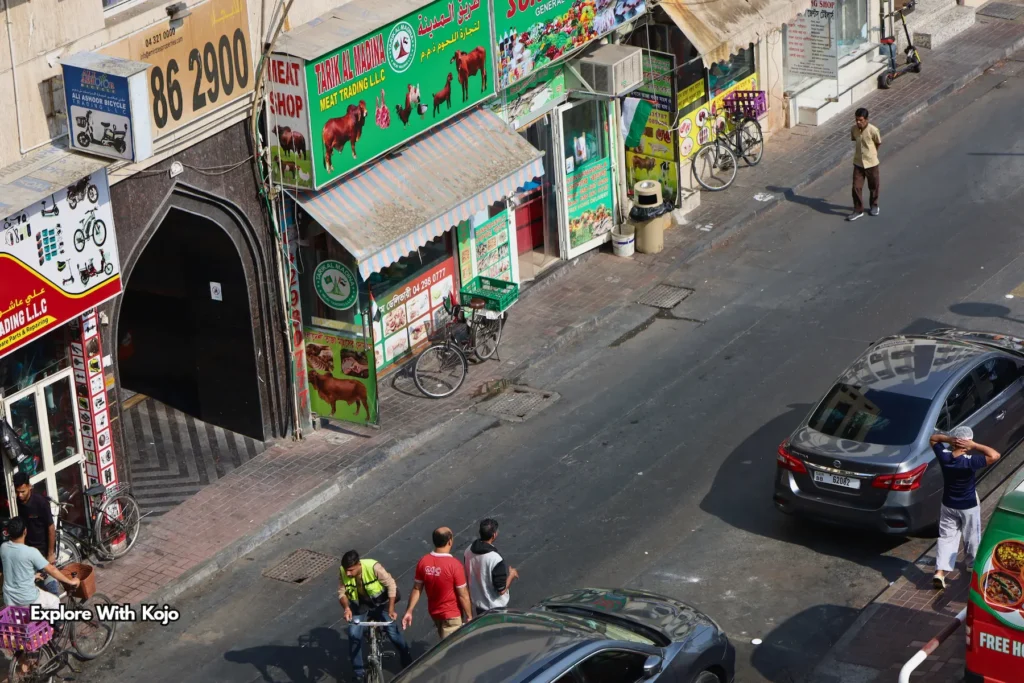 Busy Deira street lined with small meat shops and bicycle deliveries