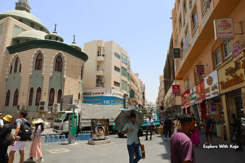 Mosque surrounded by shops and pedestrians in Deira, Dubai