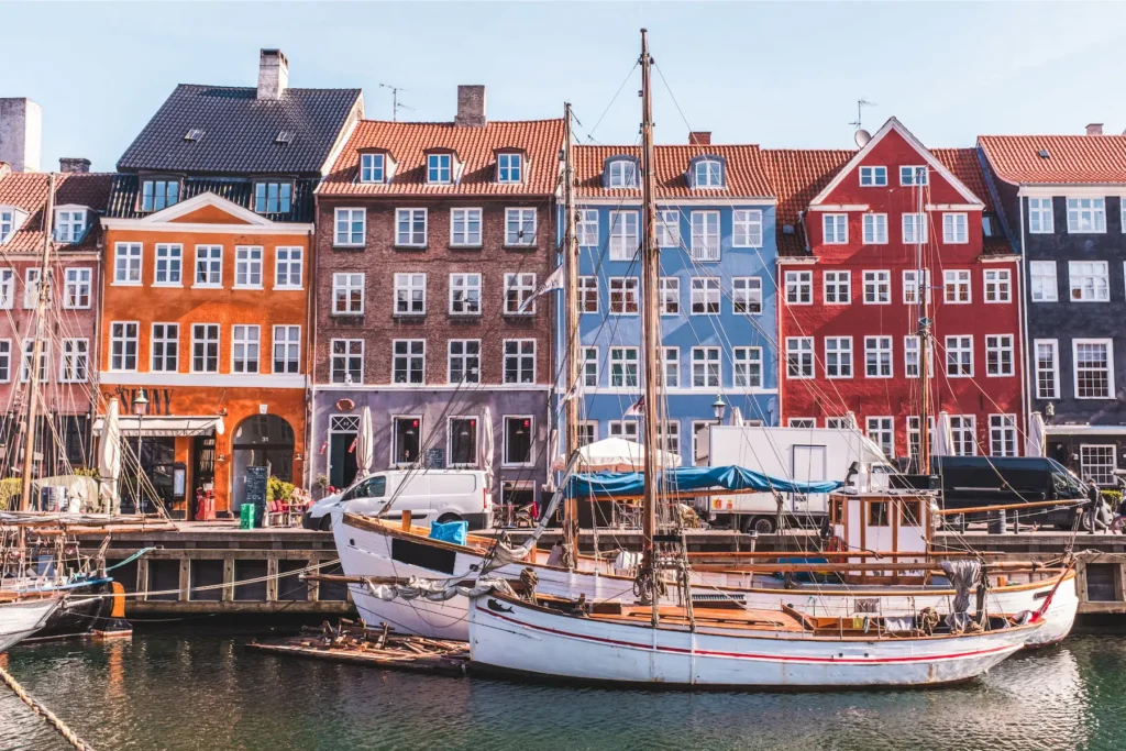 Colorful waterfront houses at Nyhavn in Copenhagen, Denmark with boats docked along the canal