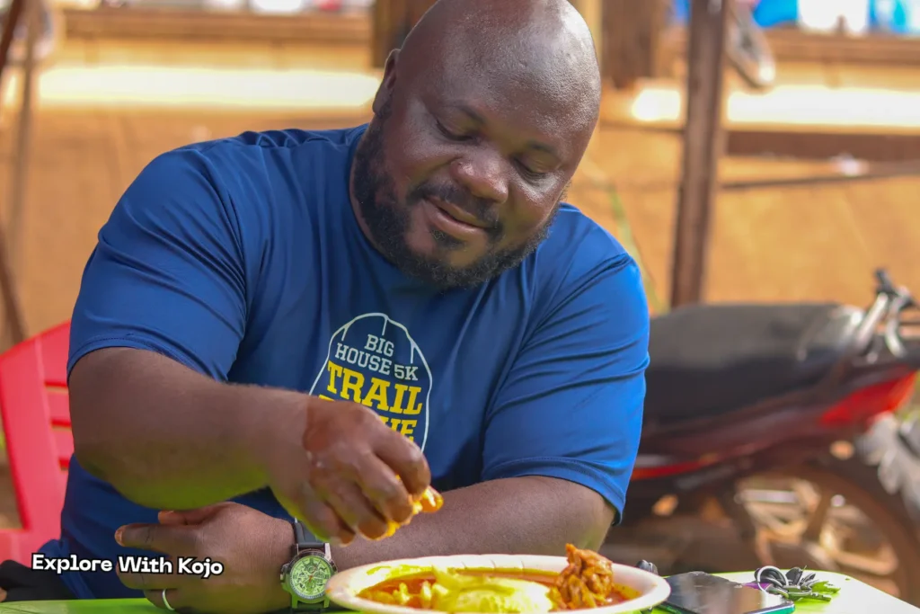 A man about to eat fufu and palm nut soup at a local Ghanaian food spot.