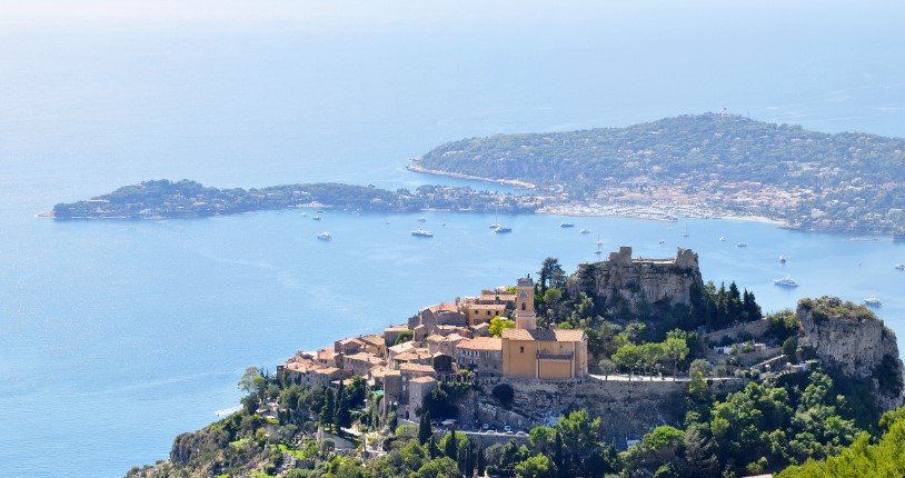 French Riviera coastline with blue waters and luxury yachts.