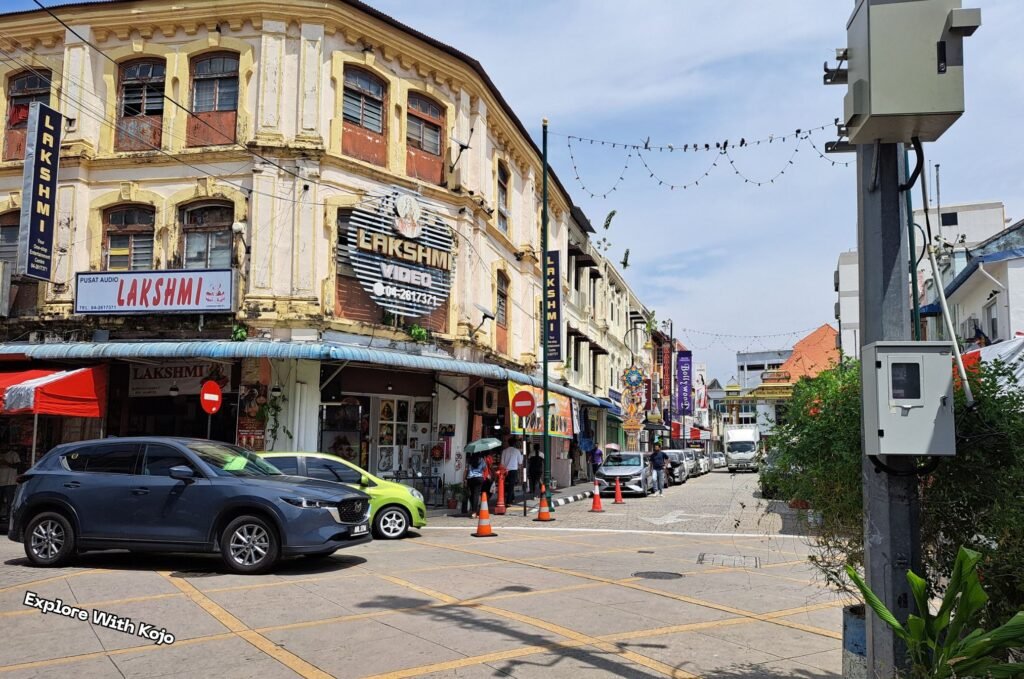 Photo taken by Explore With Kojo of Little India in George Town, Penang, showing colorful heritage buildings, shops, and street activity.