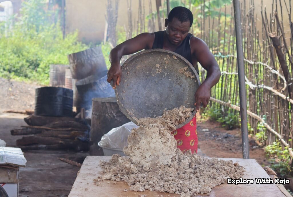 Lawrence pouring freshly cooked African black soap onto a table to cool and dry in Ghana.