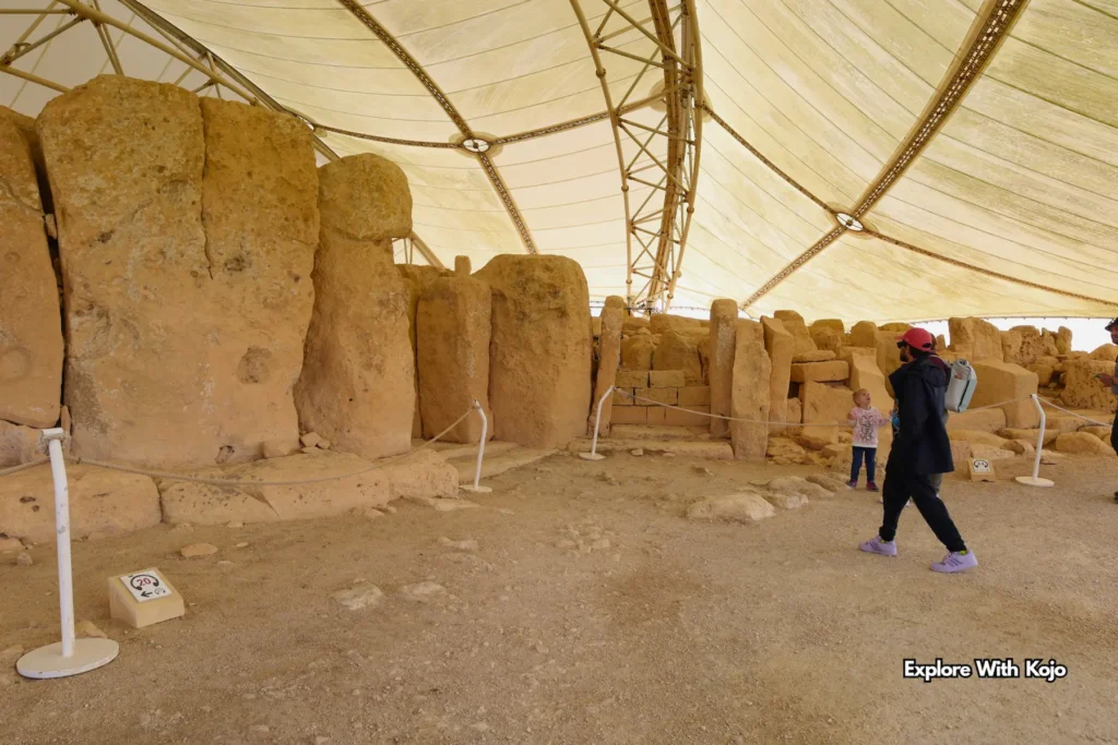 Visitor exploring Hagar Qim Temple under canopy in Malta