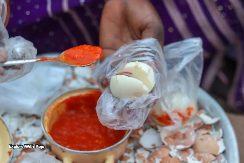 Ghanaian street food kosua ne meko, boiled egg with pepper sauce