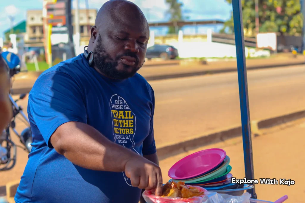 A man taking a bite of tubaani at a roadside stall in Ghana.