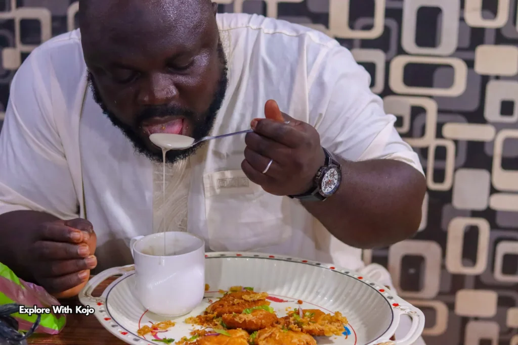 Man eating Hausa koko with koose for breakfast in Ghana