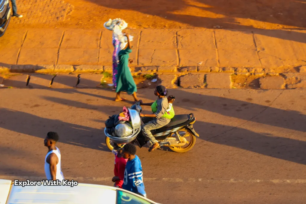 Mother riding a motorbike with her baby in Tamale, Ghana