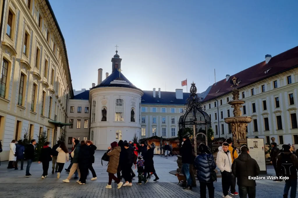 Tourists in Prague’s Old Town Square with historic architecture in the background.