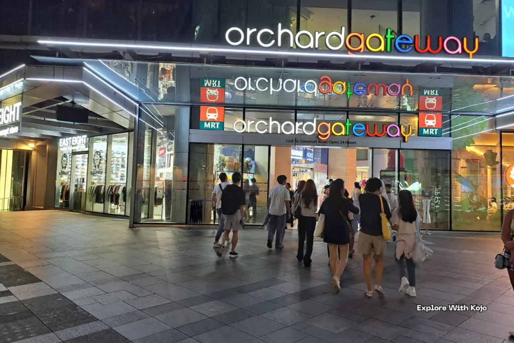 Orchard Gateway entrance lit up at night.